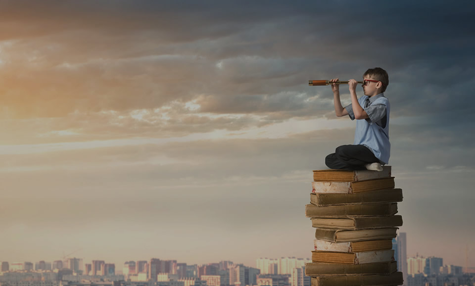 Boy sitting on a stack of books looking for a digital marketing blog
